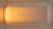 A warm light field crossed by diminishing cool tick marks, evoking a Thermage tip shot count counting down